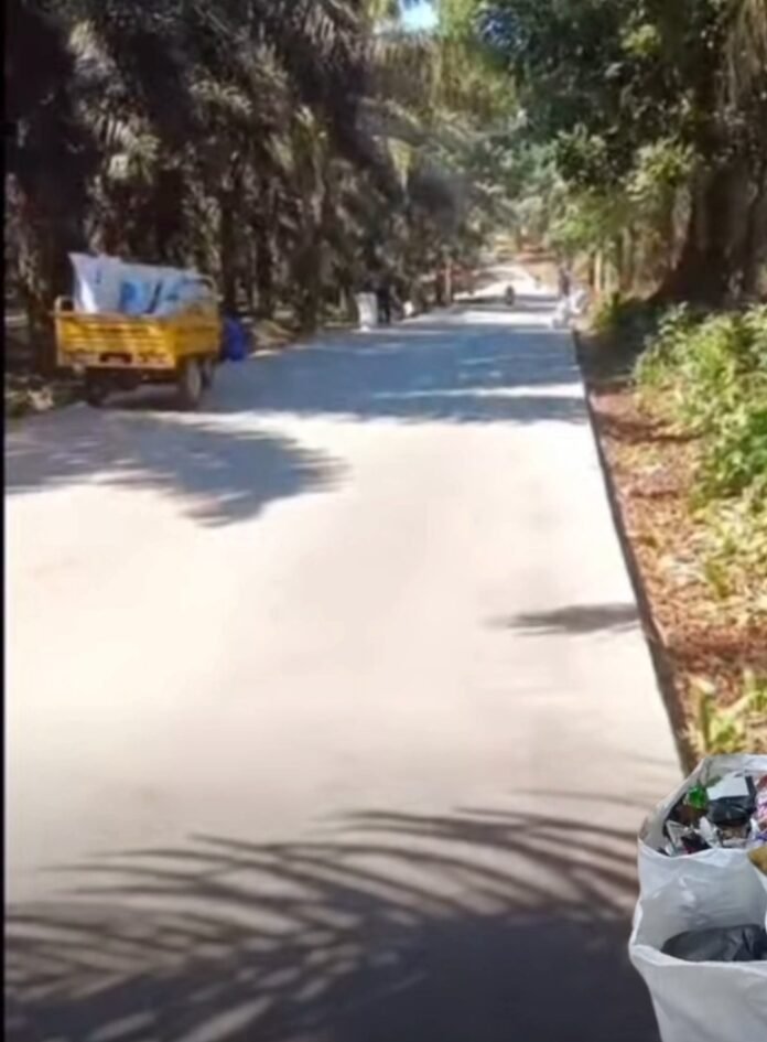 Kades desa kumpay Gercep tangani sampah di jalan baru kumpay